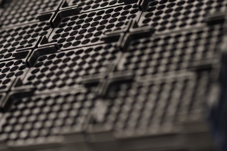 Close-up van een zwart thermohardend onderdeel met rasterstructuur